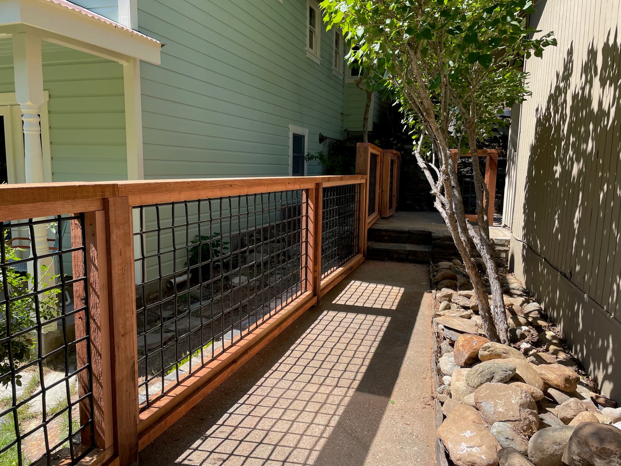 Fence along side of house with steps and rock landscaping