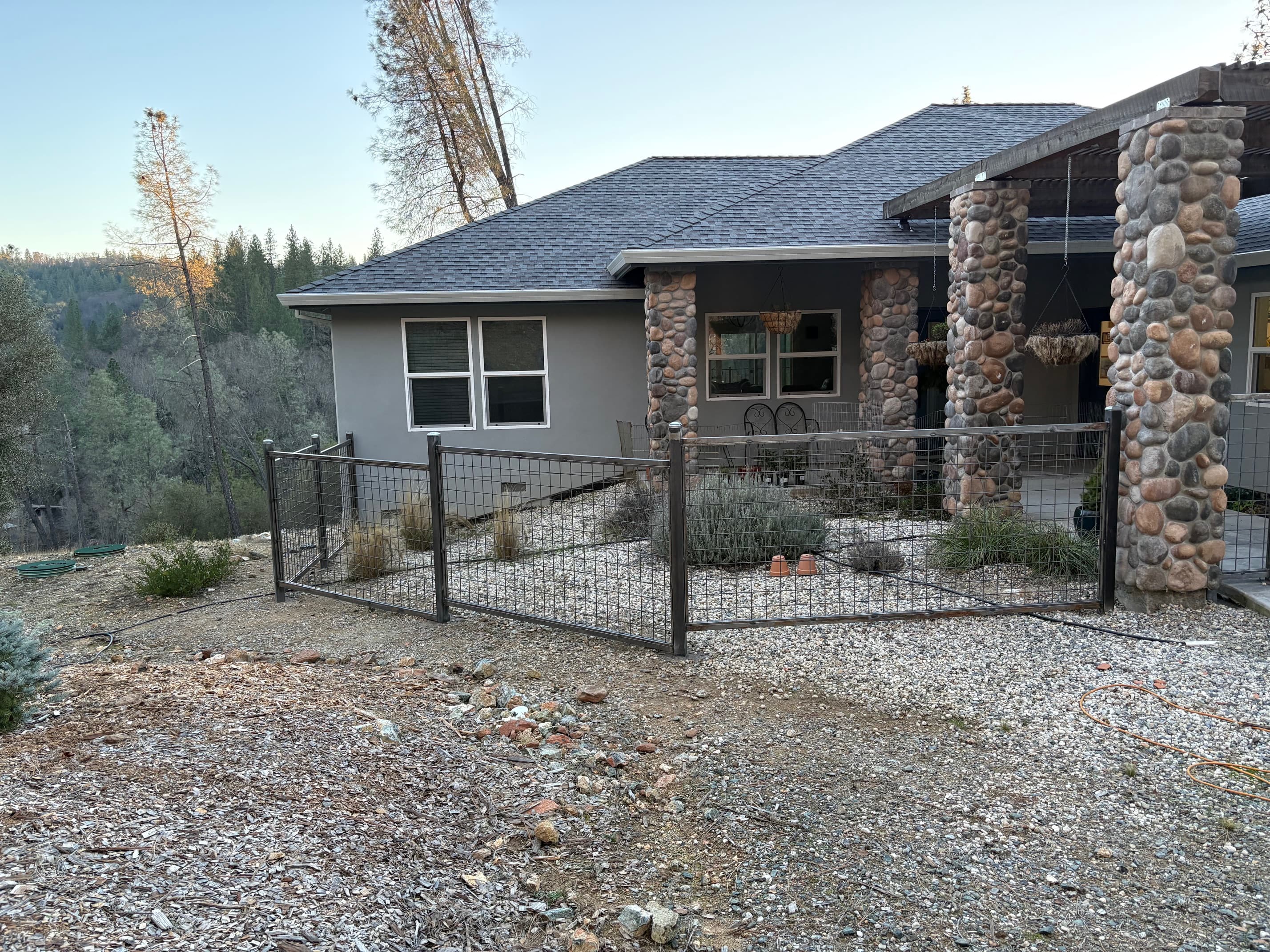 Custom steel post and wire yard fence on rural property