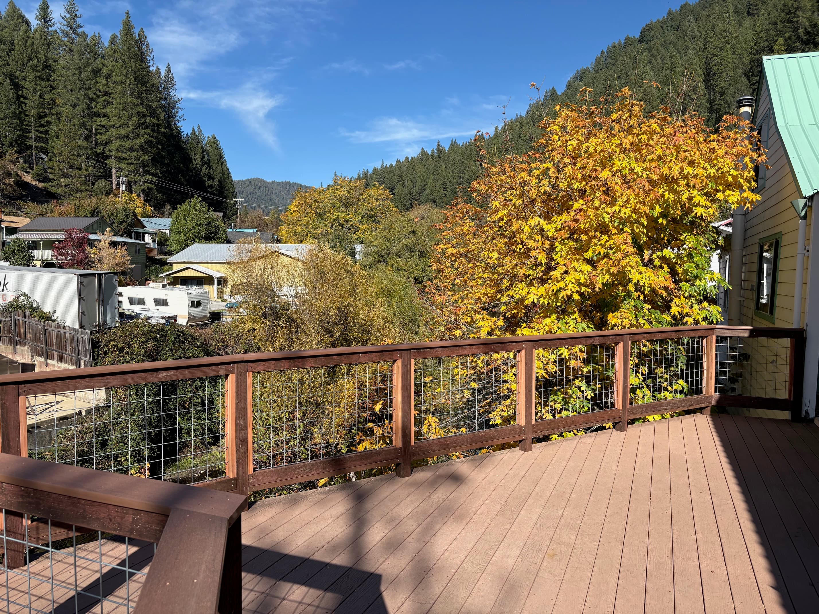 Deck railing overlooking mountain town and fall foliage