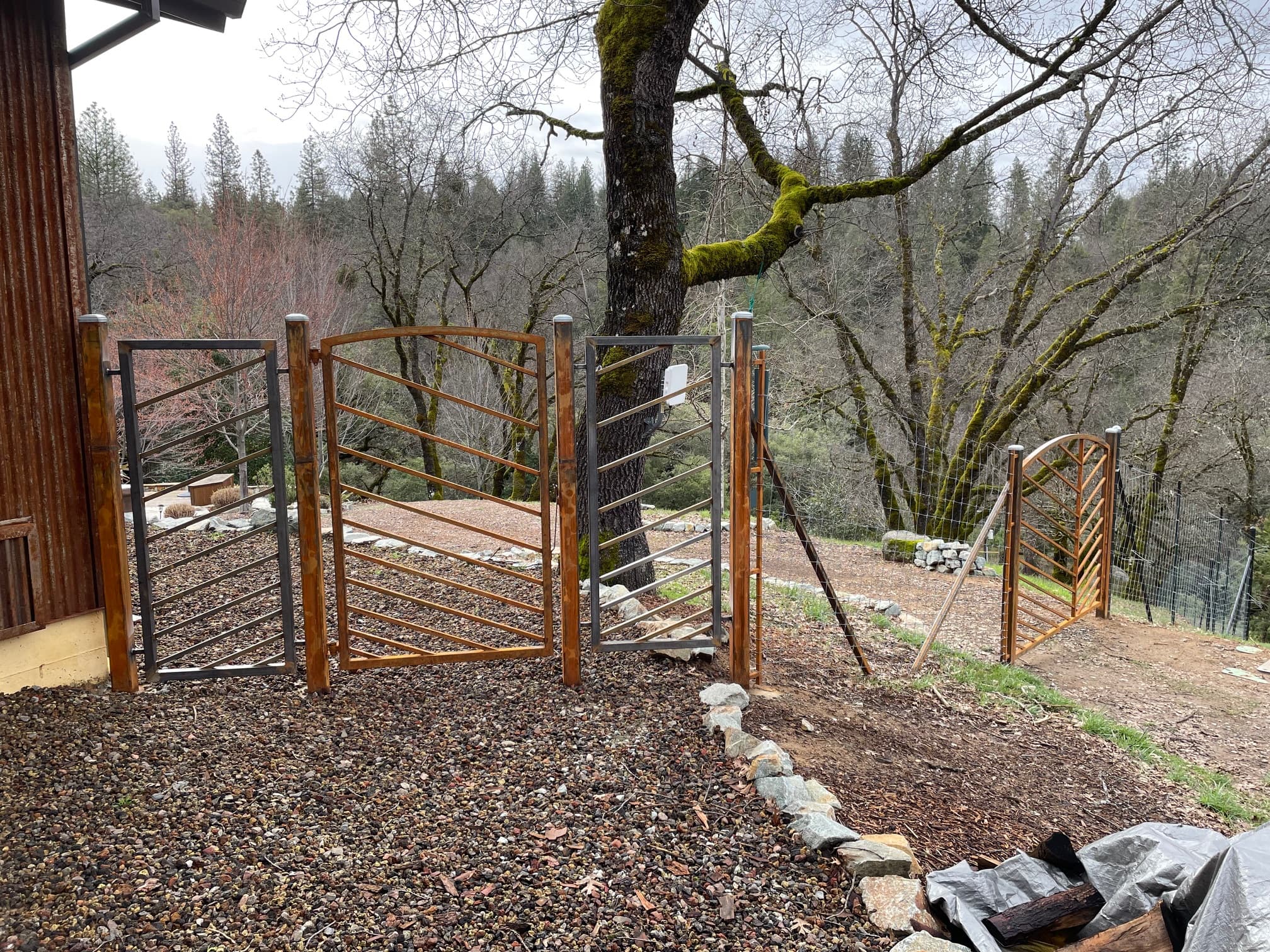 Custom wooden gate and wire fence on rural hillside property